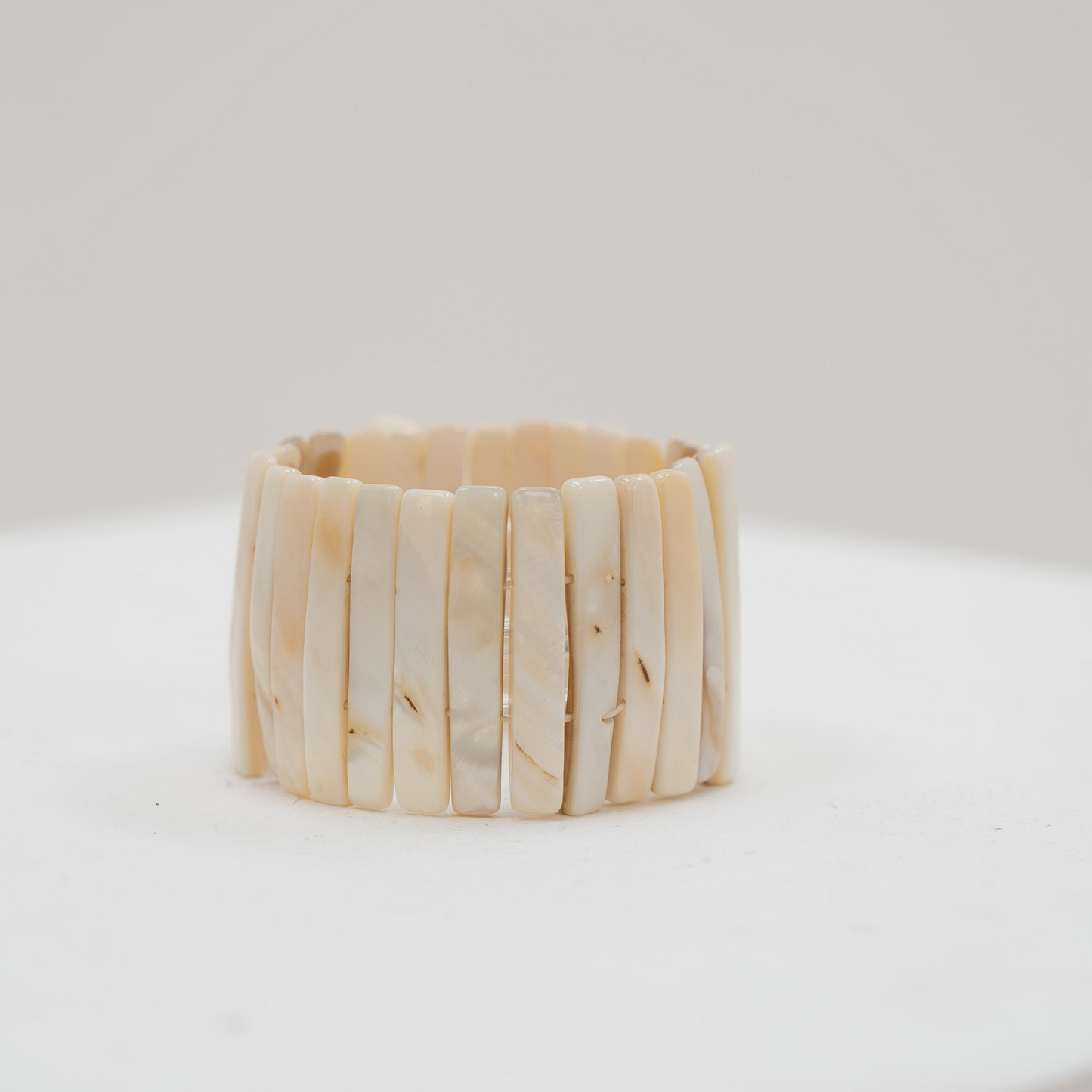 Tide Glow armband van parelmoer met unieke vorm en lichte crèmetinten op witte achtergrond