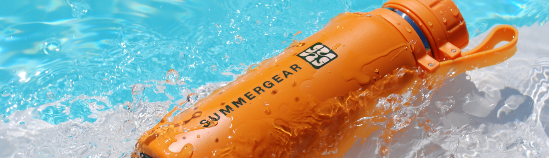 Oranje RVS drinkfles van SummerGear in het water, gebruikt als herbruikbare drinkfles voor strand, sport en onderweg