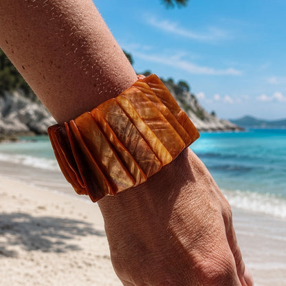 Parelmoer armband Amber Shell met oranjebruine parelmoerschakels bij zee