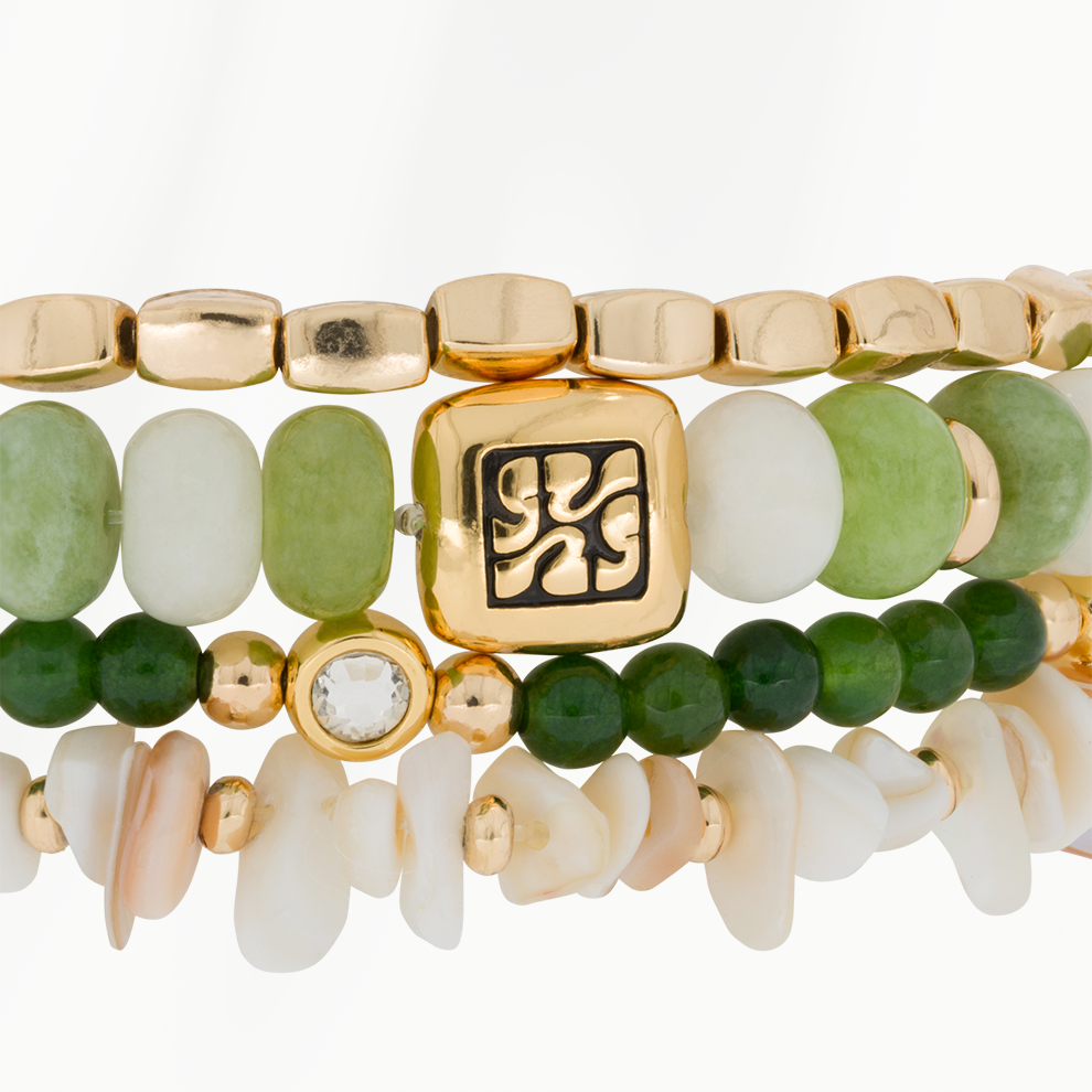 Detailfoto van de Jade Bloom armbandenset van SummerGear met groene en witte kralen, schelpdetails en goudkleurige ornamenten.