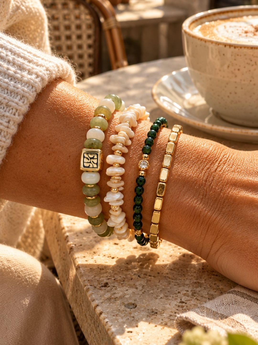Armbandenset Jade Bloom van SummerGear met groene en witte kralen, schelpdetails en goudkleurige accenten, gedragen om de pols.