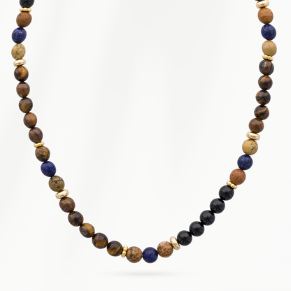 Detail van de Lava Earth kralenketting voor heren met donkerblauwe, bruine en zwarte kralen en kleine goudkleurige tussenkralen.