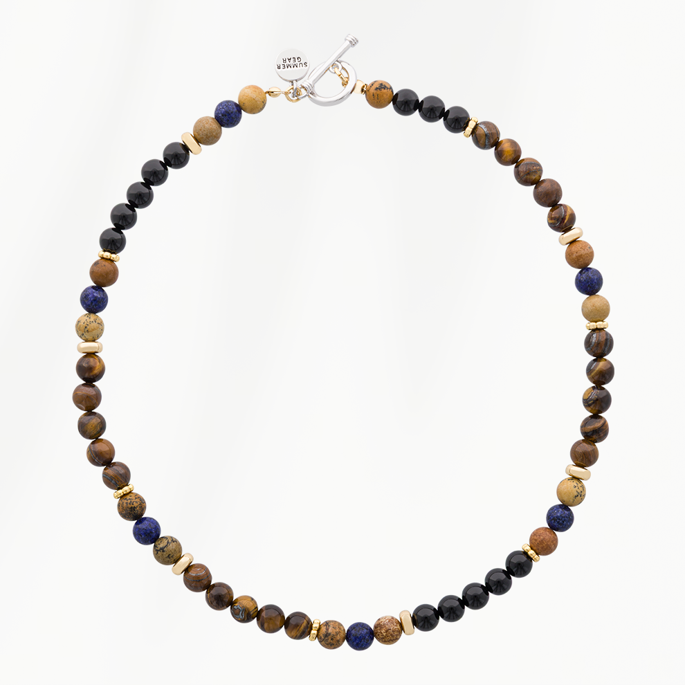 Lava Earth kralenketting voor heren met bruine, zwarte en donkerblauwe kralen, goudkleurige details en een zilverkleurige sluiting.