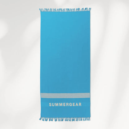 Blauwe lichtgewicht strandlaken van biologisch katoen van SummerGear volledig uitgerold in studio