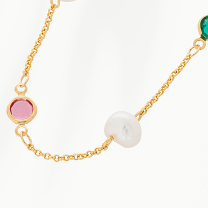 Close-up van de Color Pop parelketting van SummerGear met een witte parel, roze glazen steentje en fijne goudvergulde schakels. 
