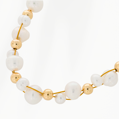 Close-up van de Pure Pearl parelketting van SummerGear met echte witte parels in verschillende formaten, kleine goudvergulde kralen en een fijne goudkleurige ketting. Kopiëren