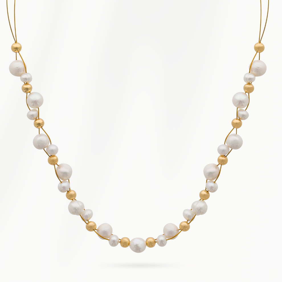 Pure Pearl parelketting van SummerGear met echte witte parels en kleine goudvergulde kralen aan een fijne goudkleurige ketting op een witte achtergrond.