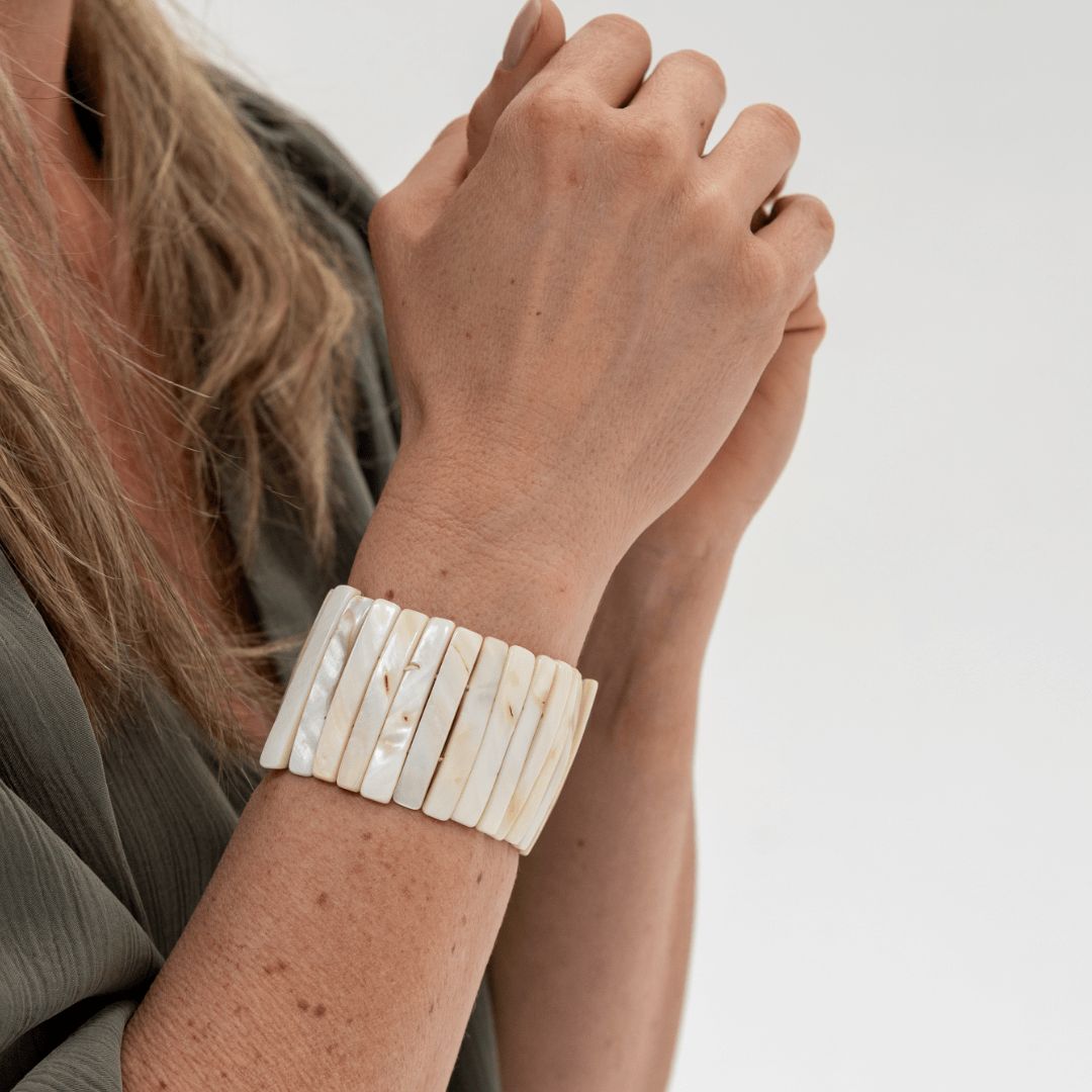 Parelmoer armband Tide Glow  gedragen om de pols met ivoorwitte parelmoer delen