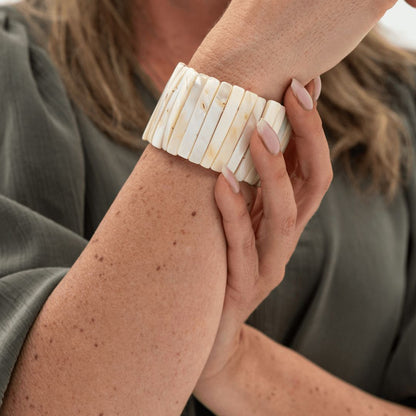 Parelmoer armband Tide Glow van 4 cm breed gedragen om de pols met ivoorwitte parelmoer delen