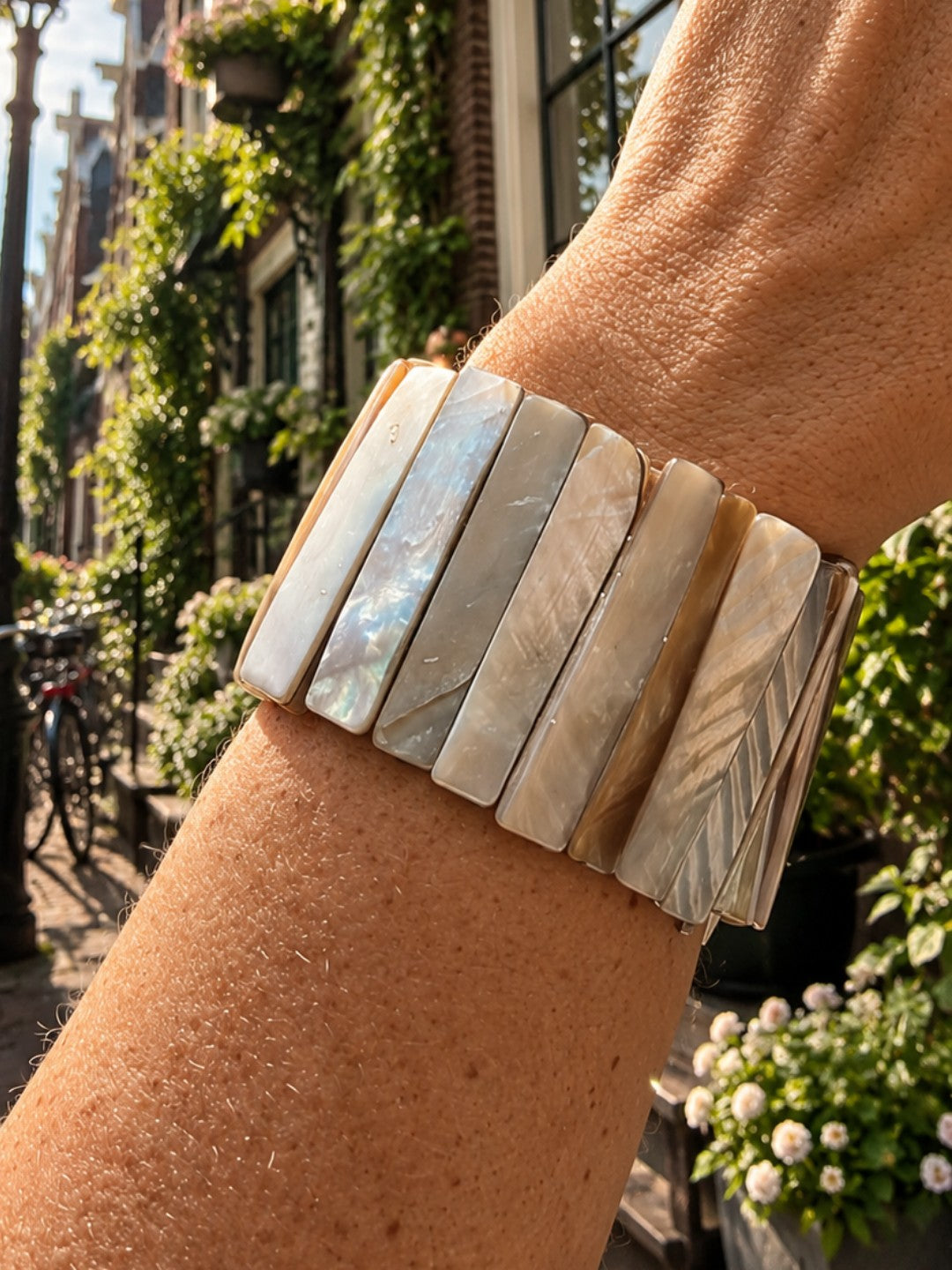 Parelmoer armband Sand Shell van SummerGear met brede lichte parelmoer elementen, gedragen om de pols