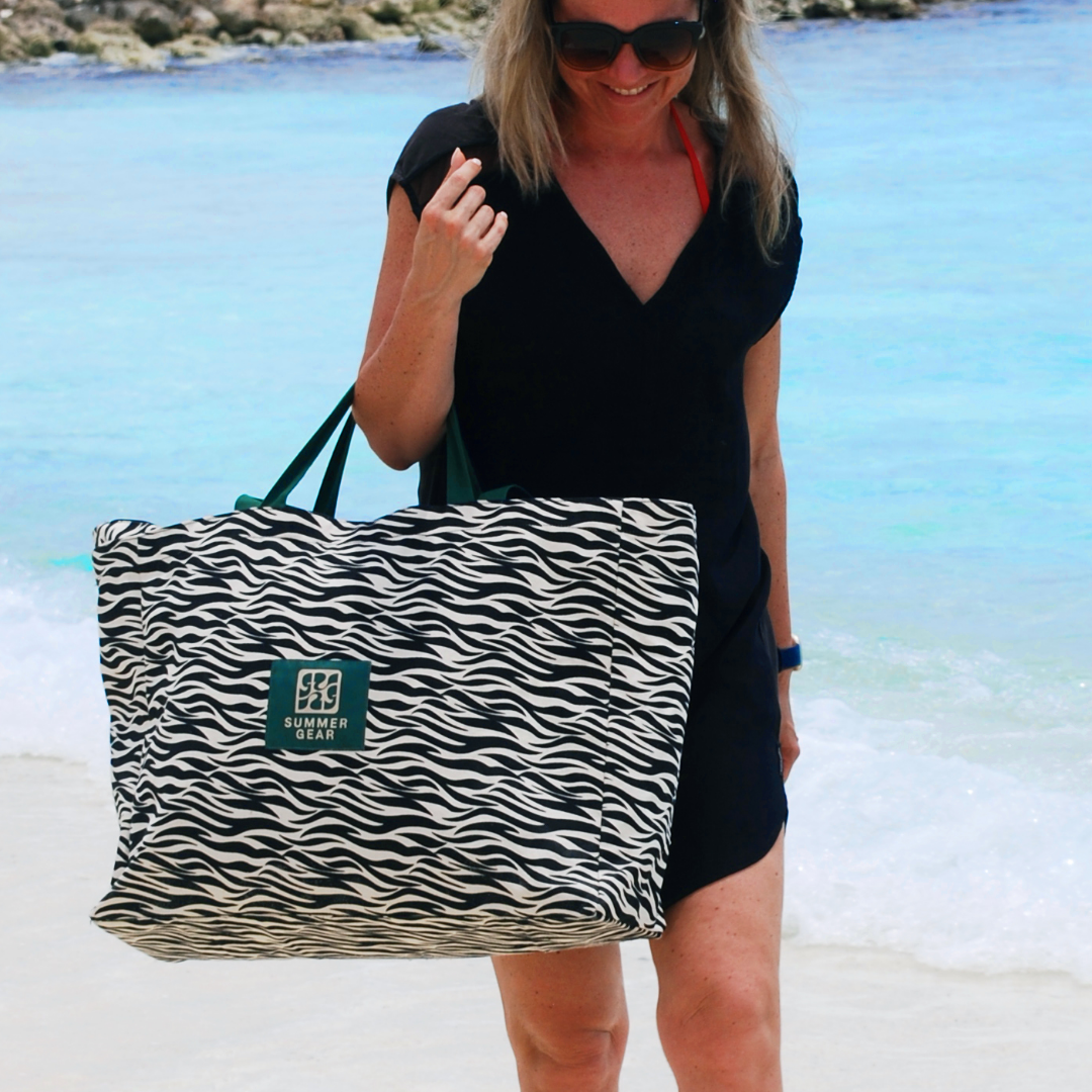 Zwarte zeebraprint SummerGear Beach Bag XL gedragen op het strand tijdens een dag buiten