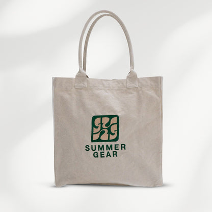 Naturelkleurige canvas shopper van SummerGear met lange schouderhengsels en donkergroen logo op de voorkant.