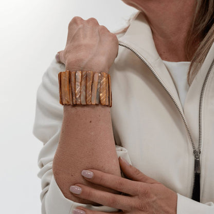 Brede karamelkleurige parelmoer armband Caramel Shell gedragen om de pols