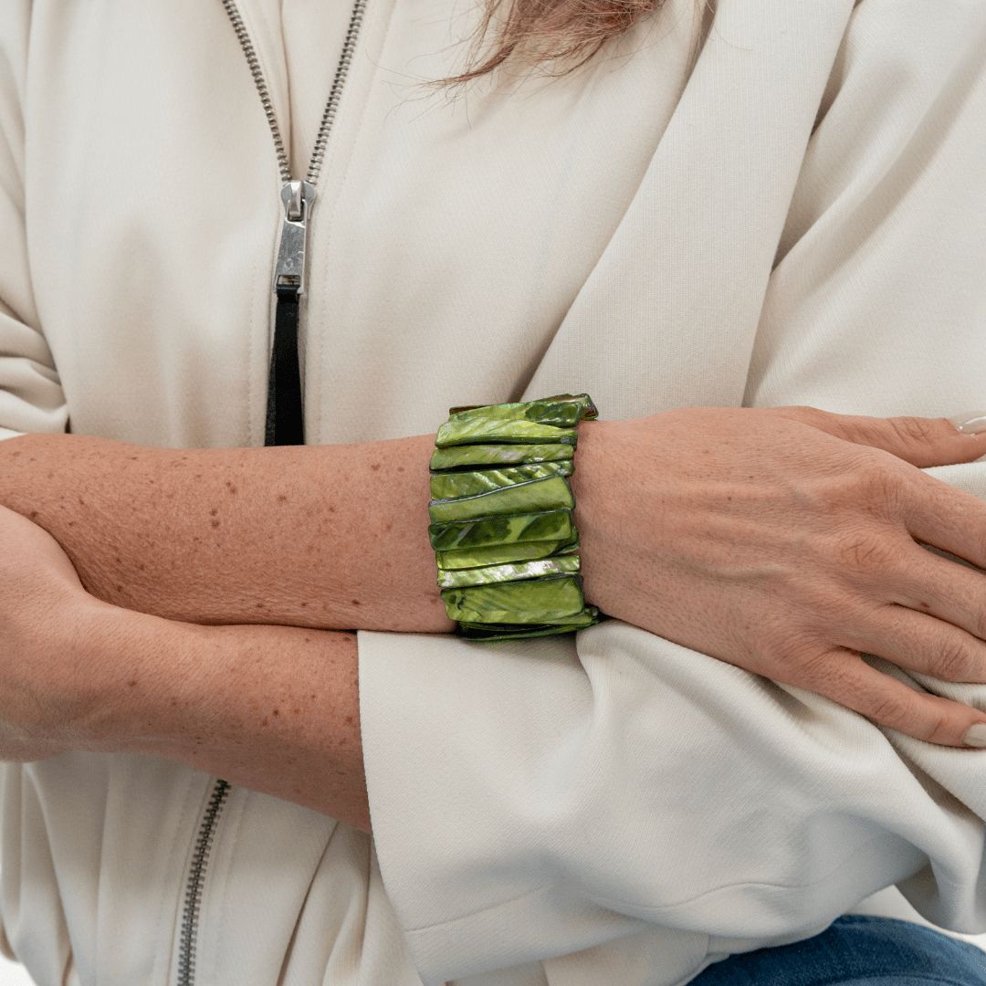 Brede olijfgroene parelmoer armband Olive Shell gedragen om de pols