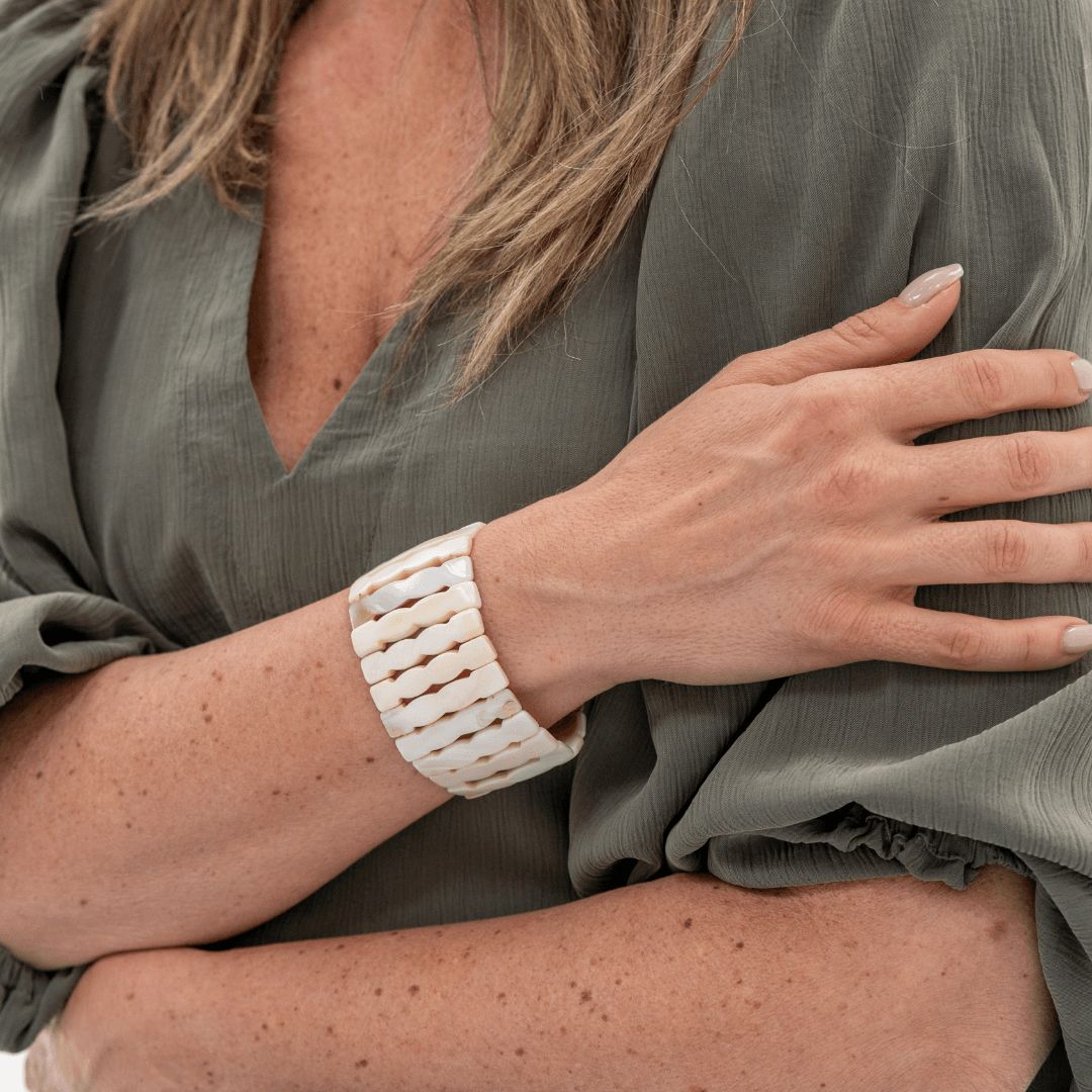 Witte brede parelmoer armband Wave gedragen om de arm