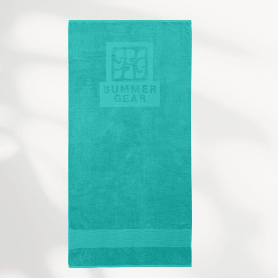 Turquoise strandlaken van biologisch katoen van SummerGear volledig uitgerold in studio