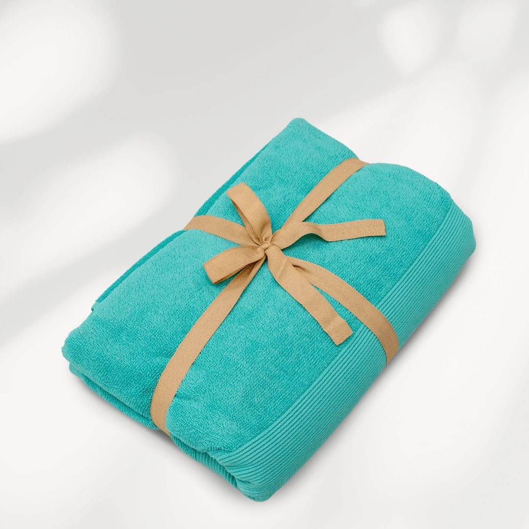 Turquoise strandlaken van biologisch katoen van SummerGear opgerold met draagband