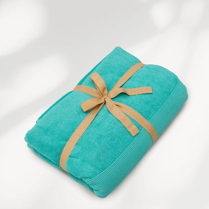 Turquoise strandlaken van biologisch katoen van SummerGear opgerold met draagband