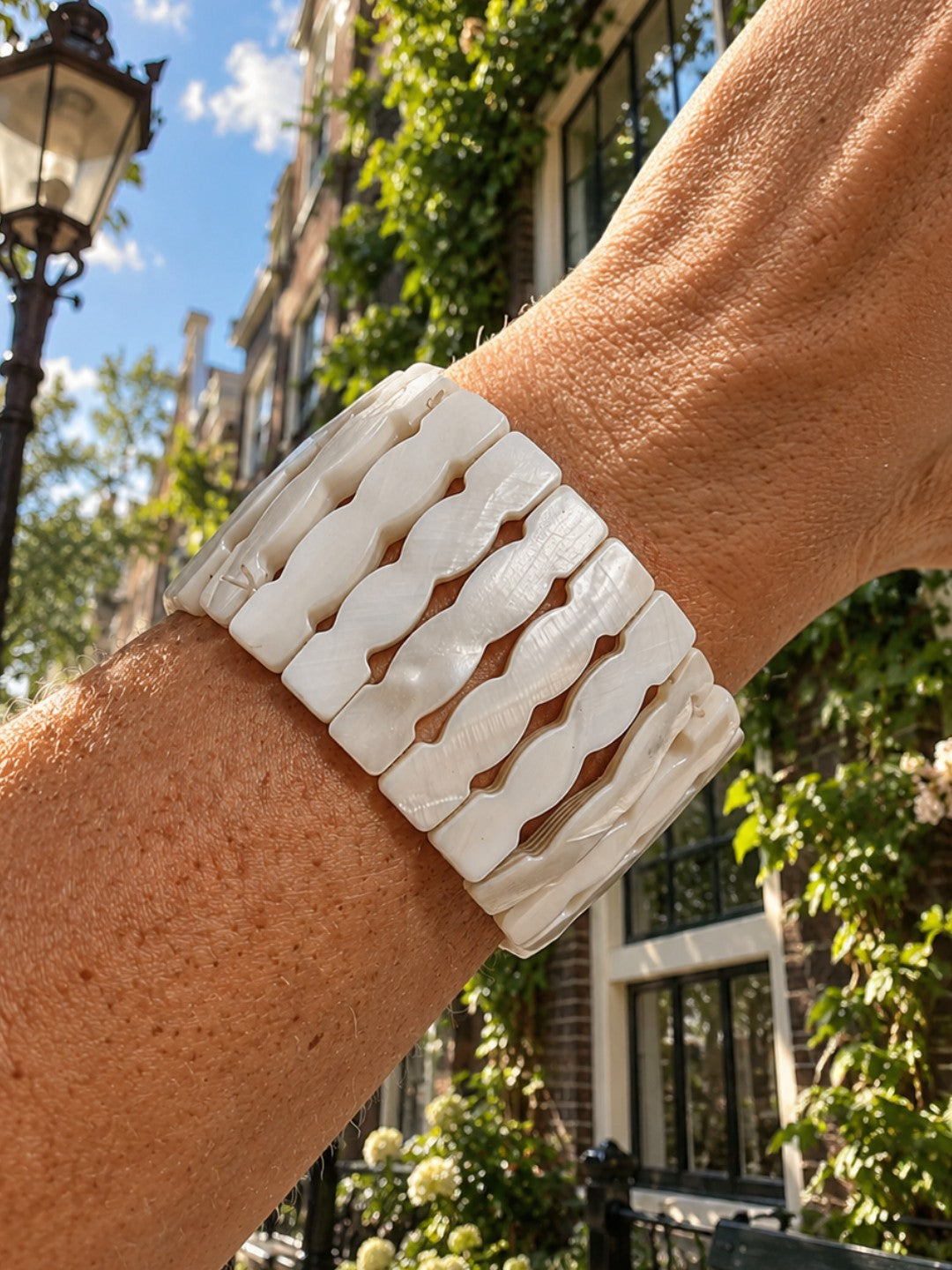 Brede parelmoer armband Wave van SummerGear in wit, gedragen om de pols